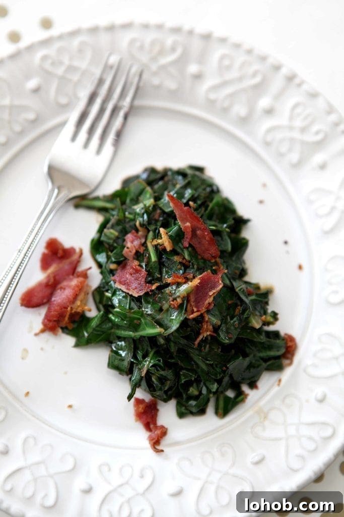 Smoky Bacon Collard Greens Recipe That Melts in Your Mouth 3 Bacon Collard Greens, served on a white plate, and topped with additional bacon
