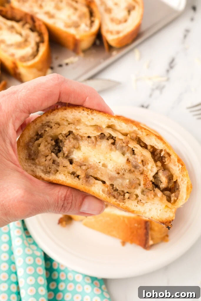 Homemade Sausage Bread Recipe: Savory Stuffed Loaf for Any Meal 2 hand holding slice of sausage bread