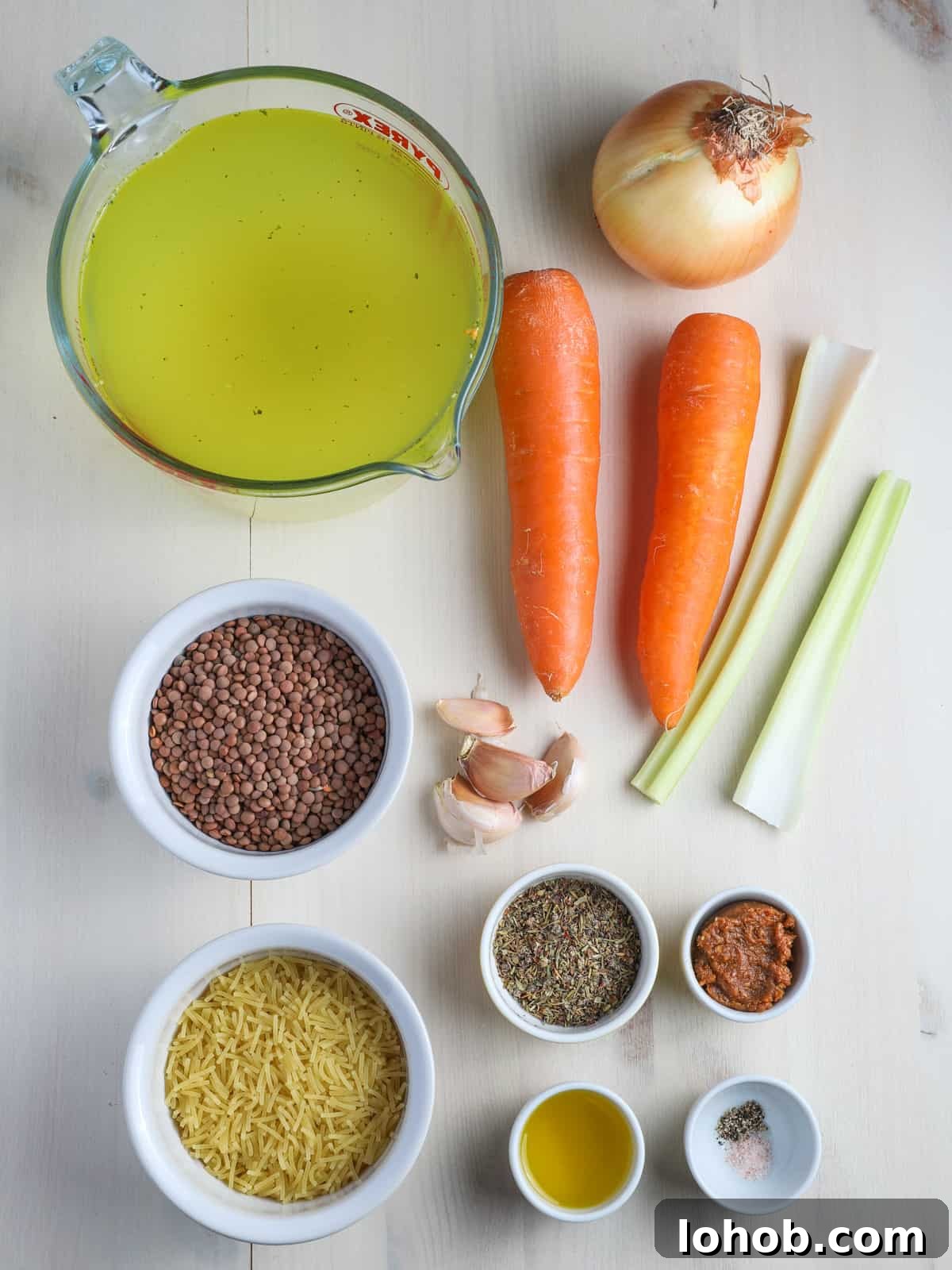 Hearty Vegan Lentil and Vegetable Noodle Soup Recipe 4 Photo showing the ingredients for this vegan lentil & vegetable noodle soup all laid out individually on a whitewashed table.