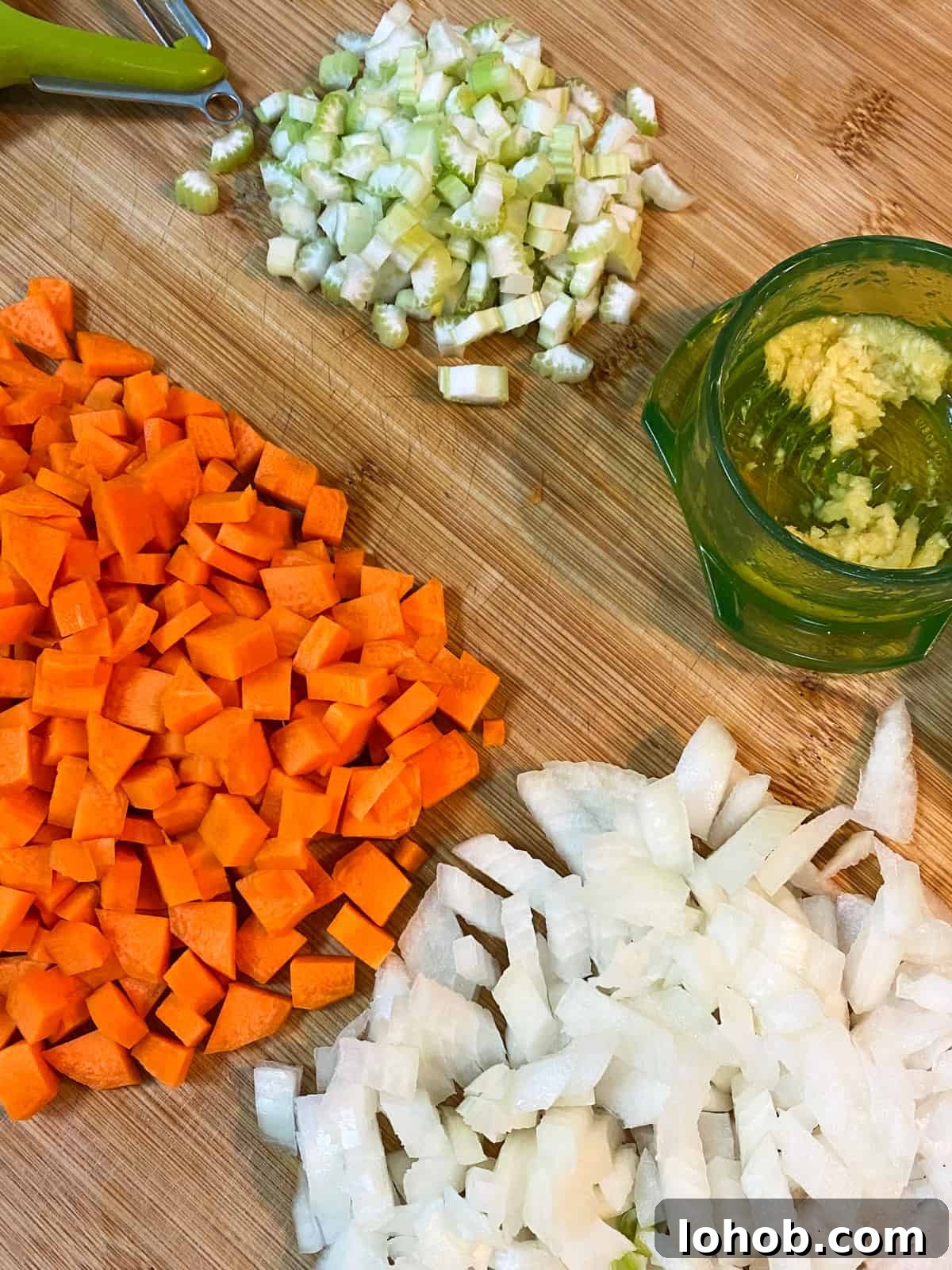 Hearty Vegan Lentil and Vegetable Noodle Soup Recipe 5 Method photo 1 showing chopped up veggies on a board.