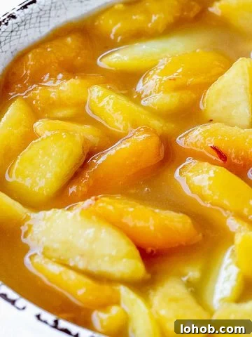 Peach pie filling in white bowl with brown rim.