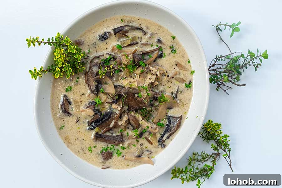 mushroom soup in a bowl topped with fresh thyme