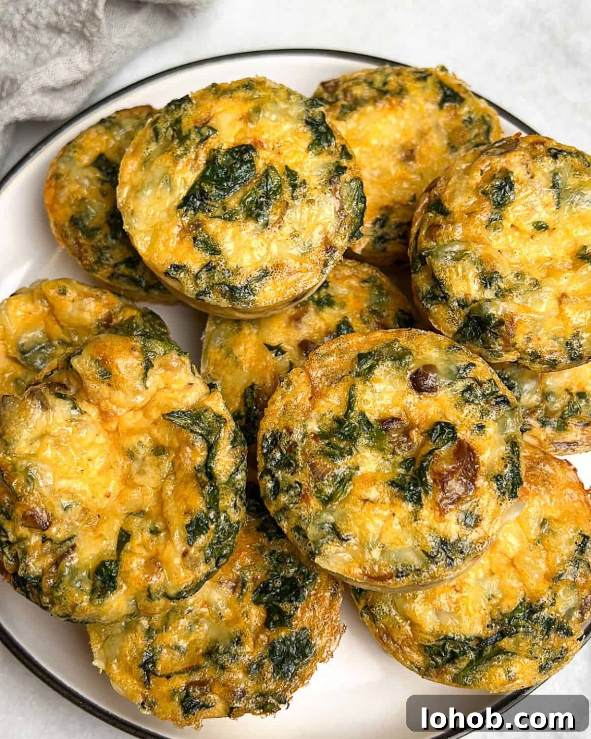 These kale and mushroom egg bites bring all the fluffy, protein-packed goodness of the Starbucks original, with a few flavor-packed upgrades! Kale and mushroom egg bites piled on a plate.