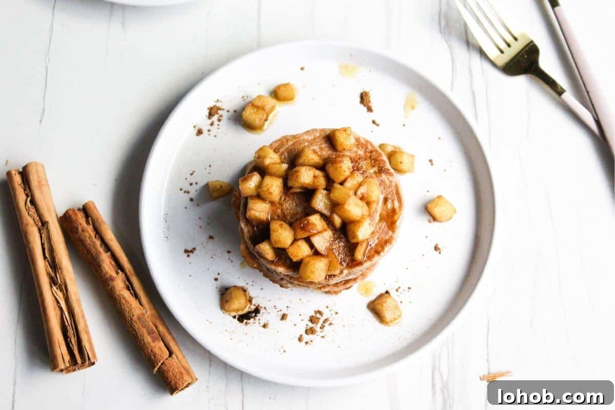 Cinnamon pancakes topped with cooked diced apples.