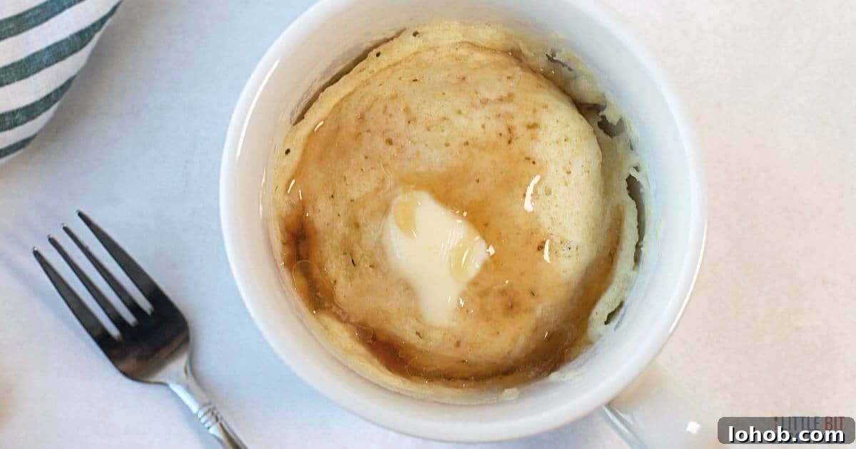 Pancake in a mug with butter and syrup.