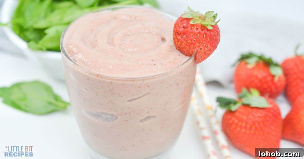 Side view of spinach strawberry smoothie in glass.