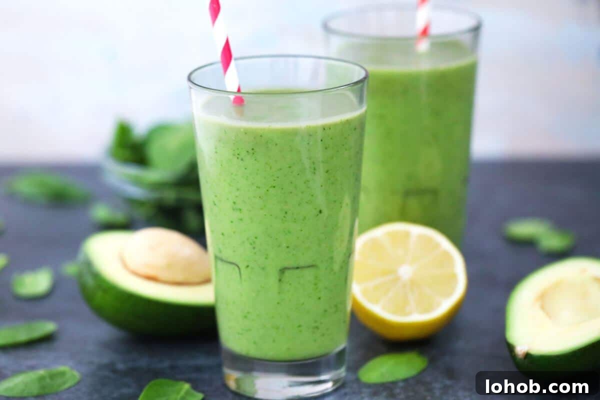 Two tall glasses of avocado spinach smoothie.