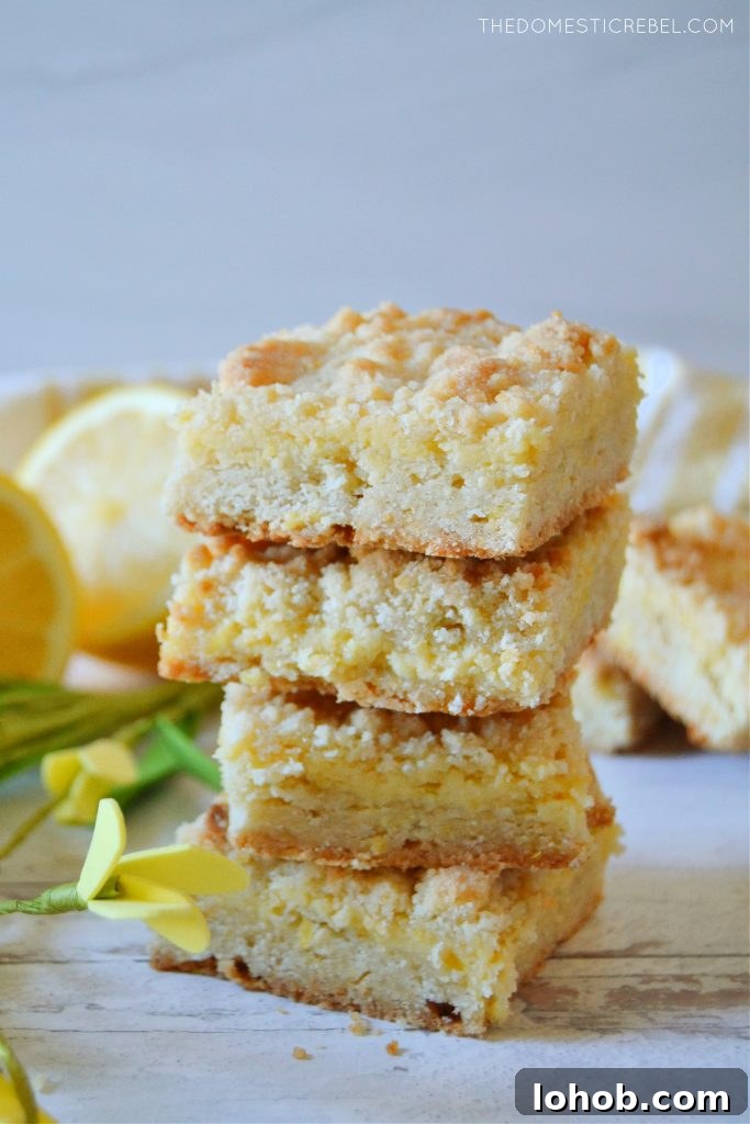 a quadruple stack of lemon crumble bars on white wood