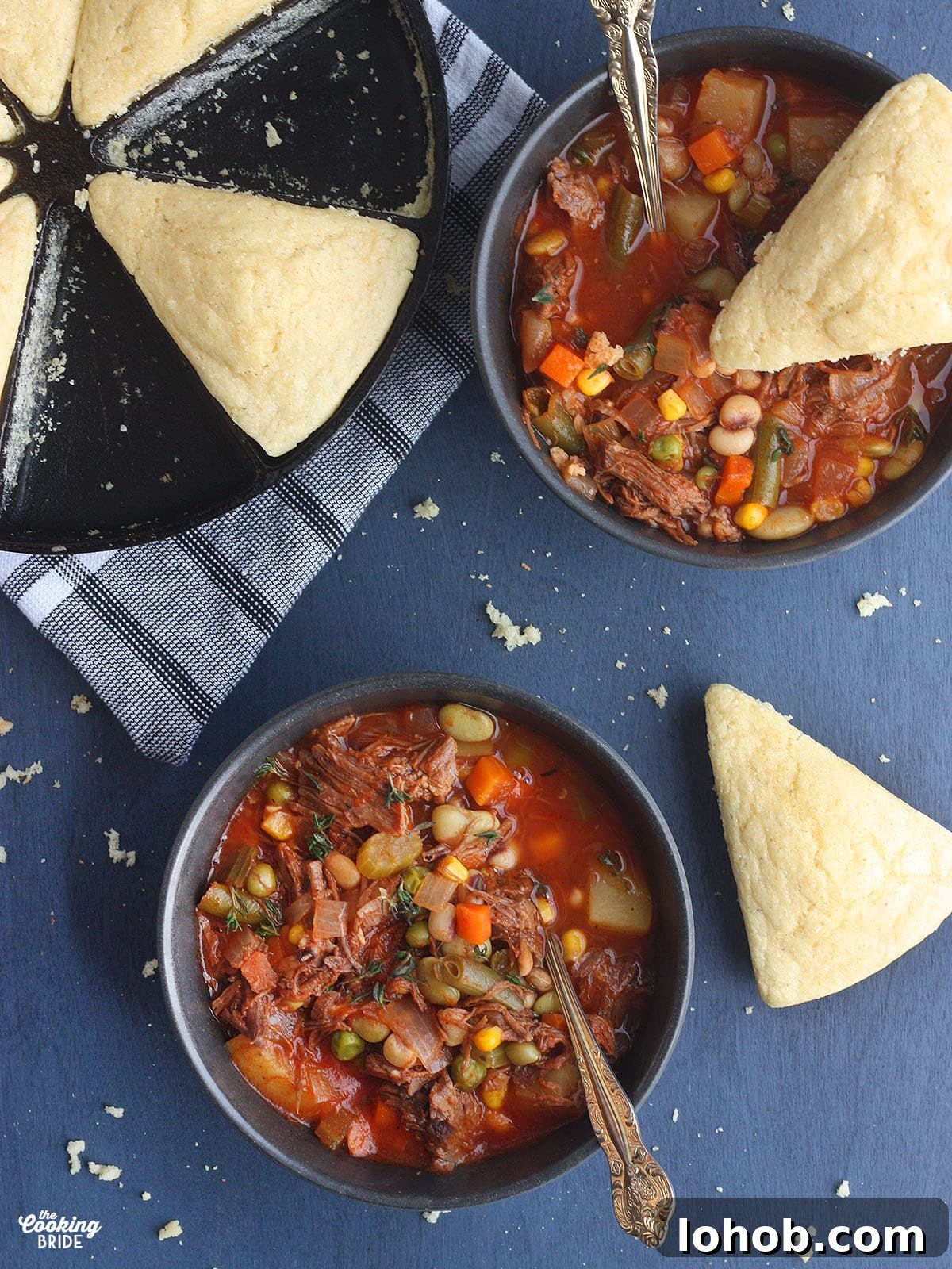 Hearty Vegetable and Beef Soup Recipe for Family Meals 2 overhead shot of two bowls of vegetable beef soup with two wedges of cornbread and a pan of cornbread to the side