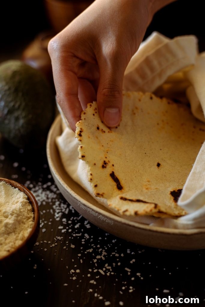 Homemade Corn Tortillas with 3 Simple Ingredients 3 Picking up a freshly made 3 ingredient corn tortilla.