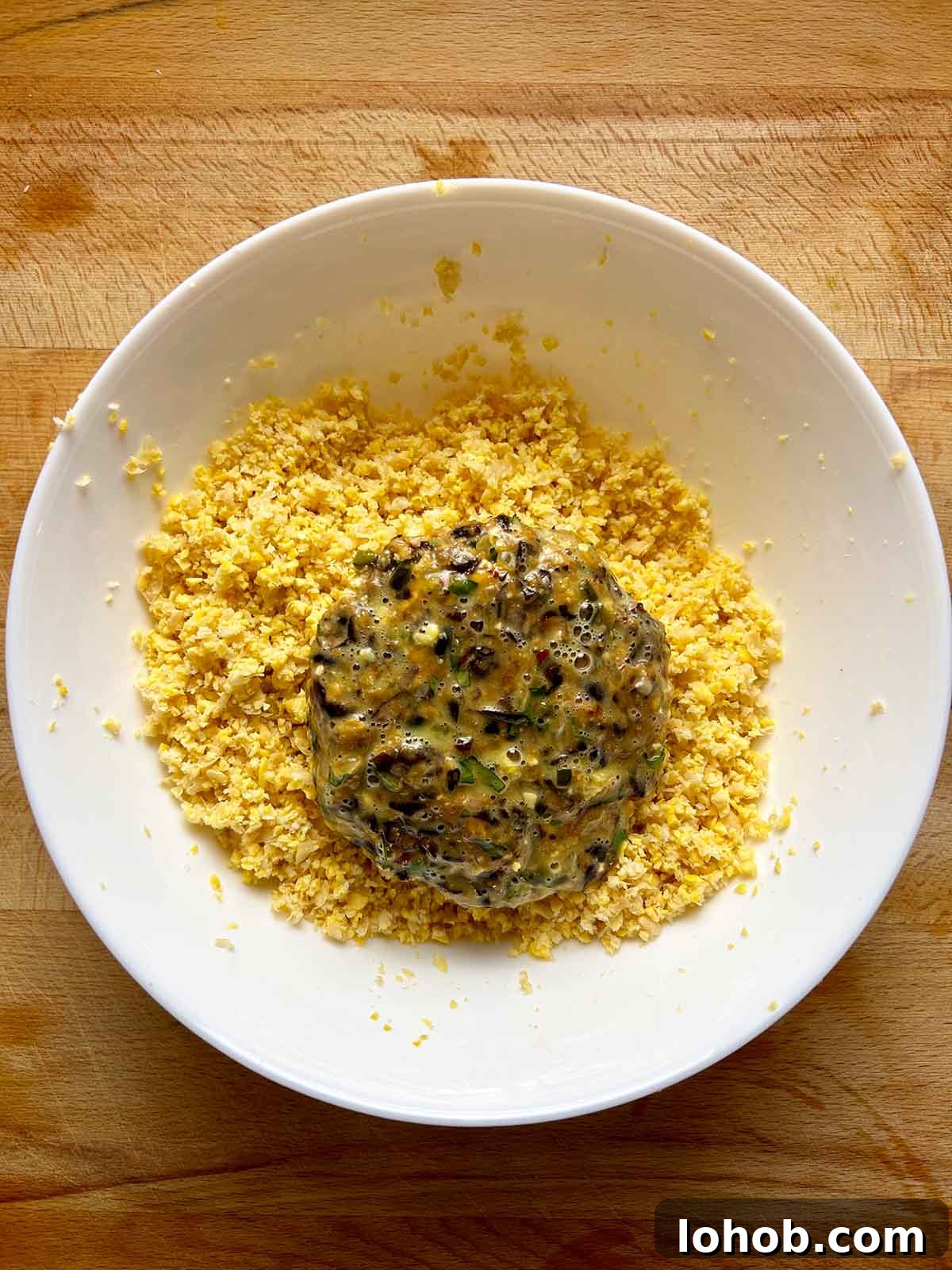Chickpea-Crusted Black Bean Burger Recipe for Crispy Veggie Burgers 13 patty in bowl of chickpea breadcrumb mixture