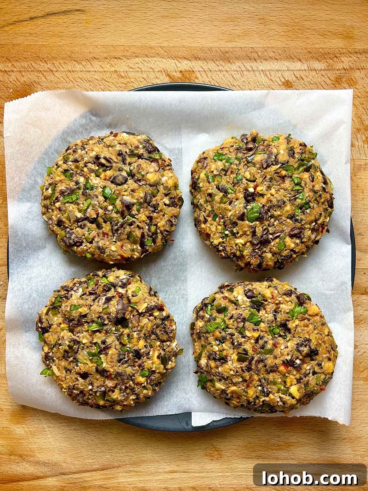 Chickpea-Crusted Black Bean Burger Recipe for Crispy Veggie Burgers 9 four shaped black bean patties on plate