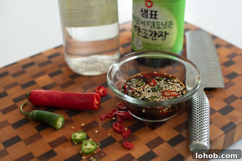 Chopped green and red chili added to soy dipping sauce for Korean potato pancakes