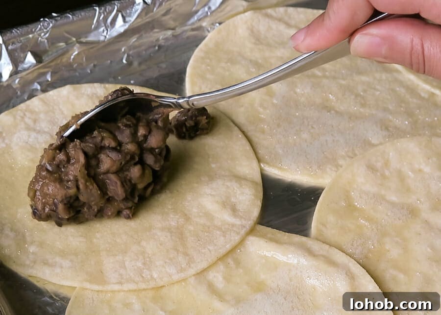 Crispy Baked Black Bean Tacos – Vegan Gluten-Free Recipe 13 filling the tortillas with the black bean mixture for the Crispy Baked Black Bean Tacos {Healthy, Vegan, Gluten-free}
