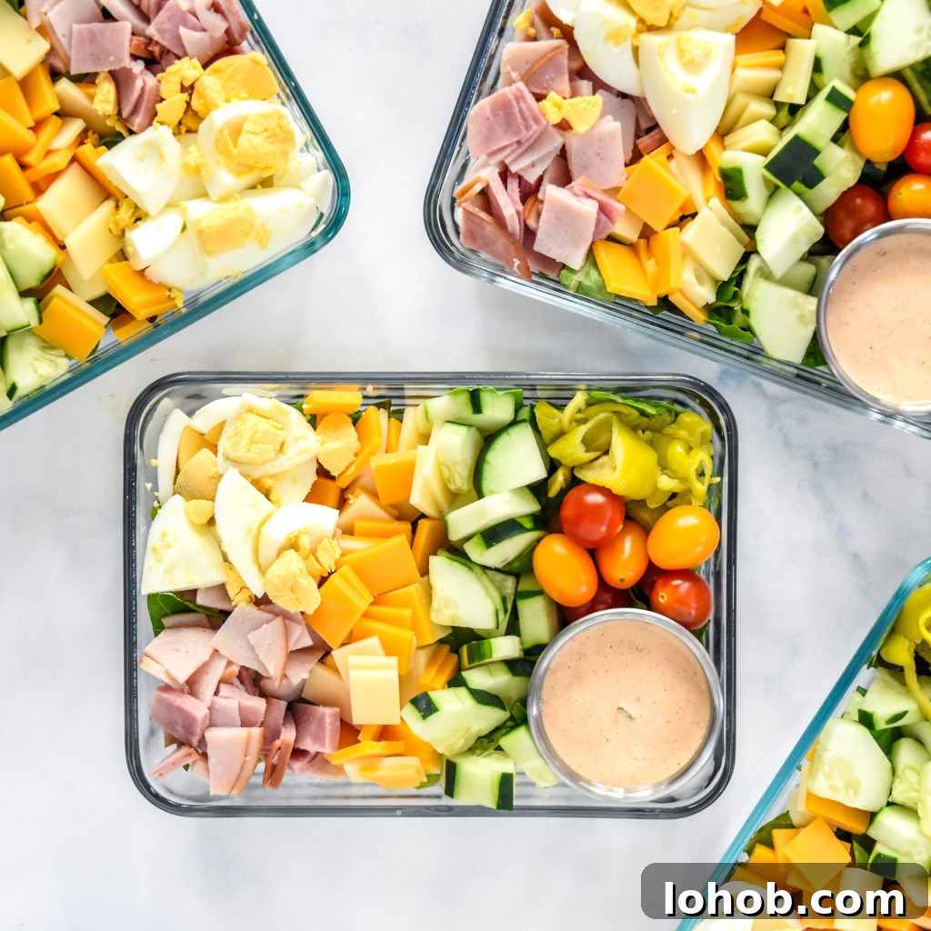 easy chef salad meal prep with dressing in rectangular glass containers.