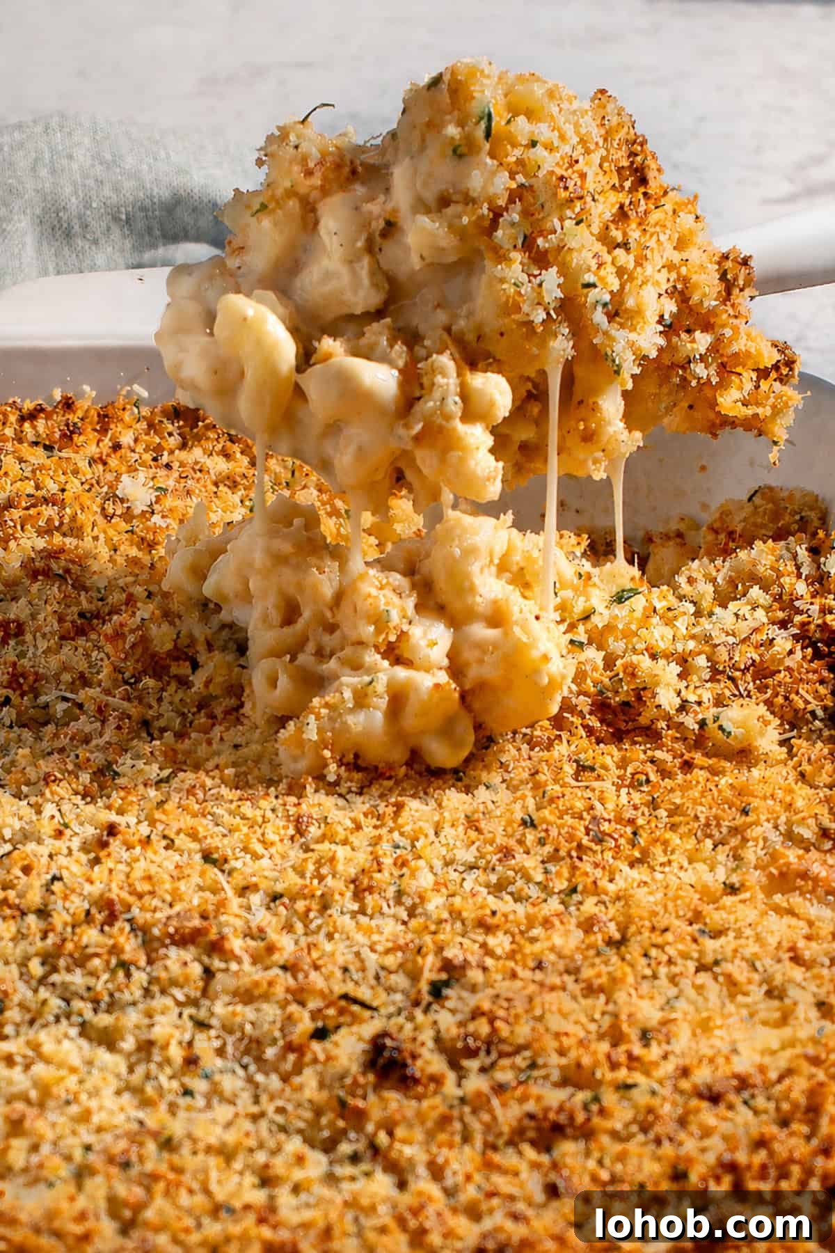 Creamy Baked Three-Cheese Macaroni with Garlic Parmesan Crumb Top 2 A scoop of baked three cheese mac and cheese with crispy garlic Parmesan crumb topping.