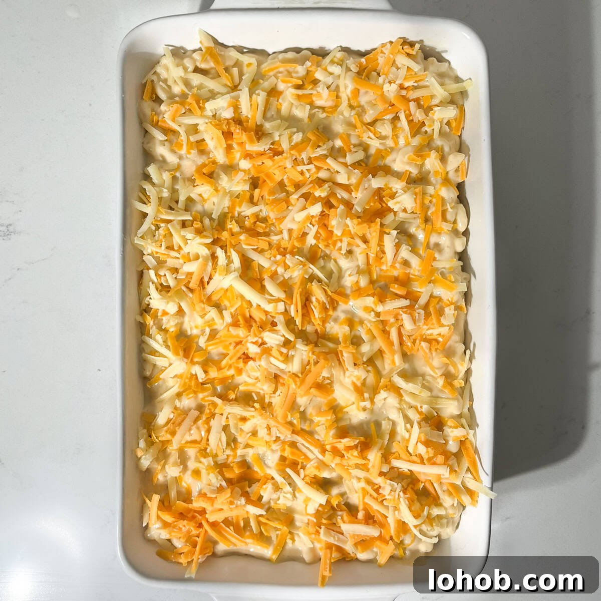 Creamy Baked Three-Cheese Macaroni with Garlic Parmesan Crumb Top 11 Three cheese mac and cheese in a large white oven dish, ready to go into the oven.