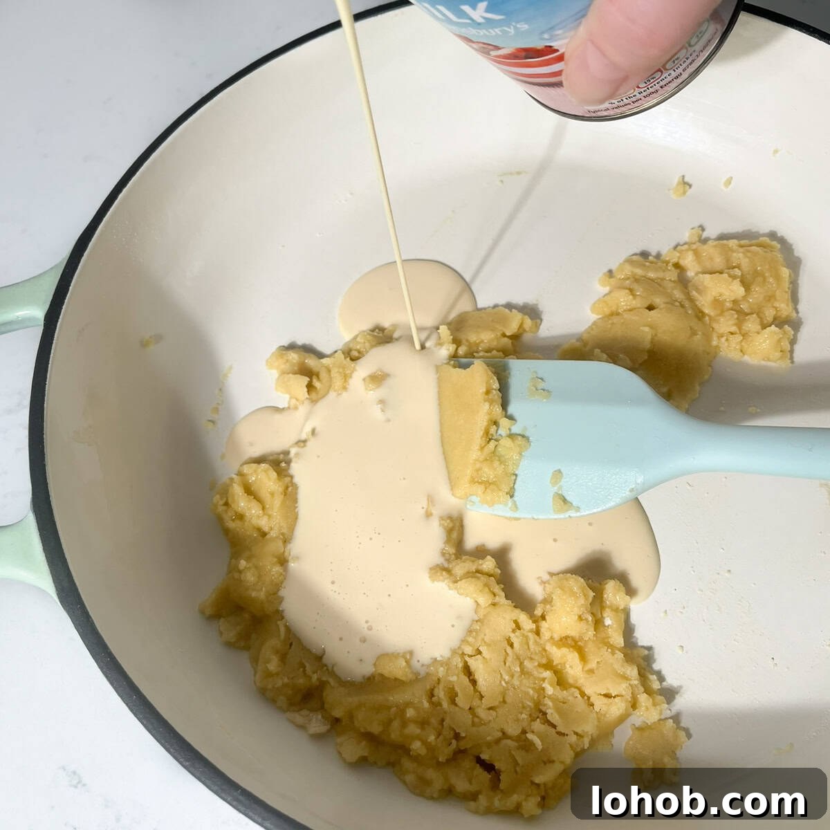 Creamy Baked Three-Cheese Macaroni with Garlic Parmesan Crumb Top 5 Adding evaporated milk to the roux in a large saucepan.