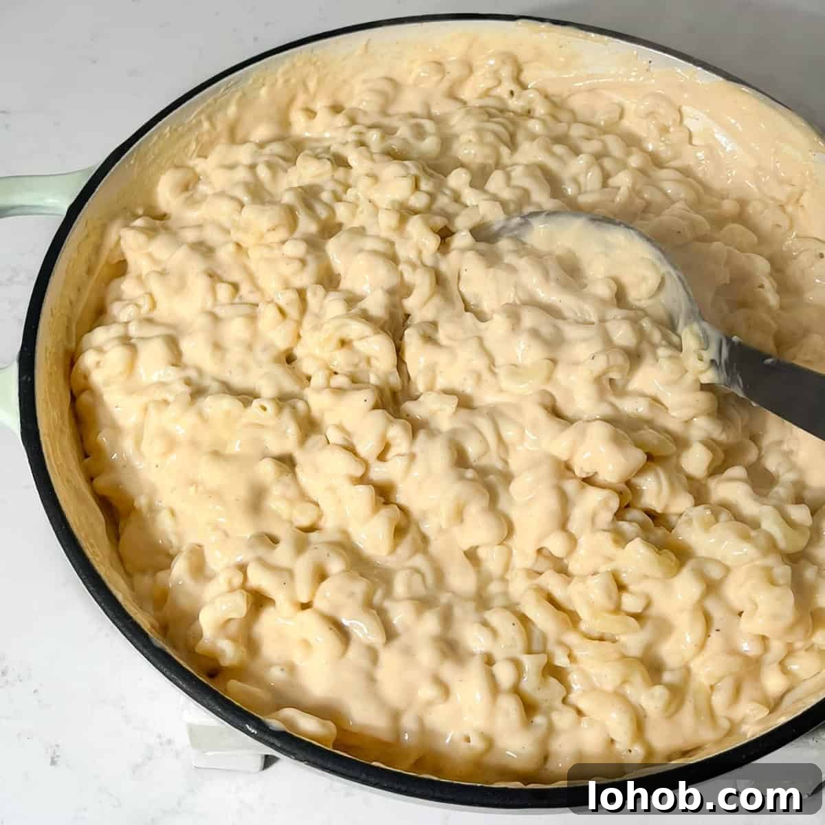 Creamy Baked Three-Cheese Macaroni with Garlic Parmesan Crumb Top 9 Macaroni and cheese in a large saucepan ready to be transferred to the oven dish.
