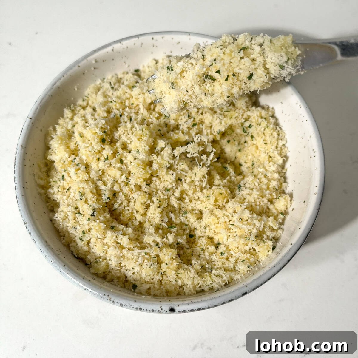 Creamy Baked Three-Cheese Macaroni with Garlic Parmesan Crumb Top 10 Mixing the parmesan and breadcrumbs in a bowl for the crumbed parmesan topping.