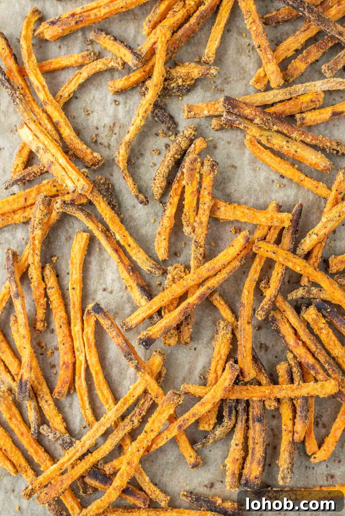 Crispy Oven-Baked Sweet Potato Fries Recipe 2 overhead shot of sweet potato fries on parchment-lined baking sheet