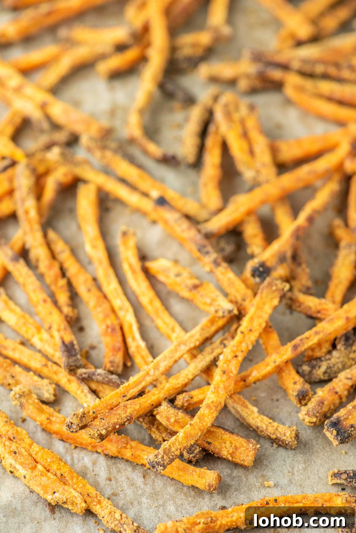 Crispy Oven-Baked Sweet Potato Fries Recipe 3 sweet potato fries on parchment-lined baking sheet