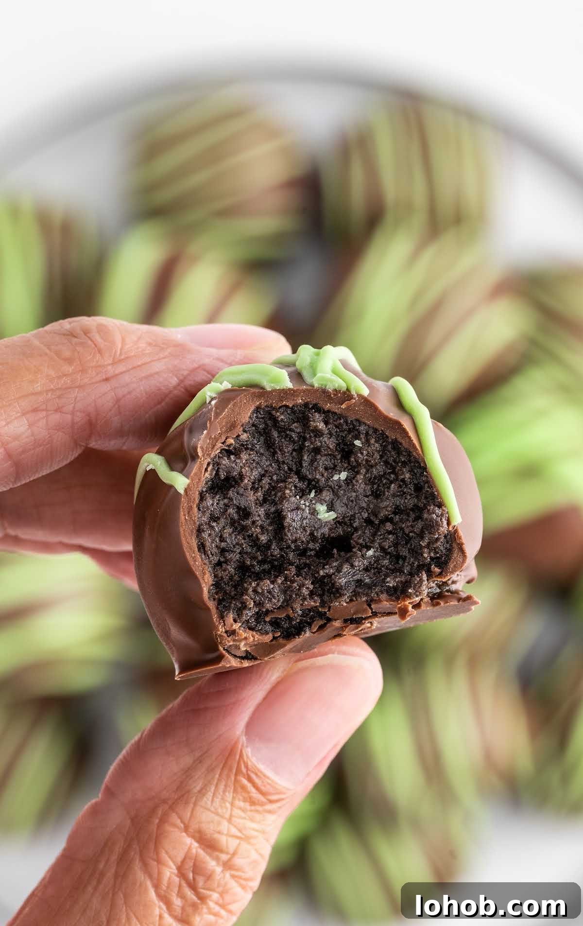 a close up shot of a Mint Oreo Truffle with a bite taken out of it