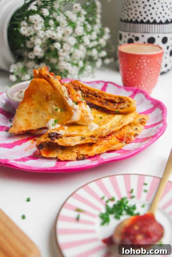Breakfast tortilla wrap sliced on a pink and white plate.