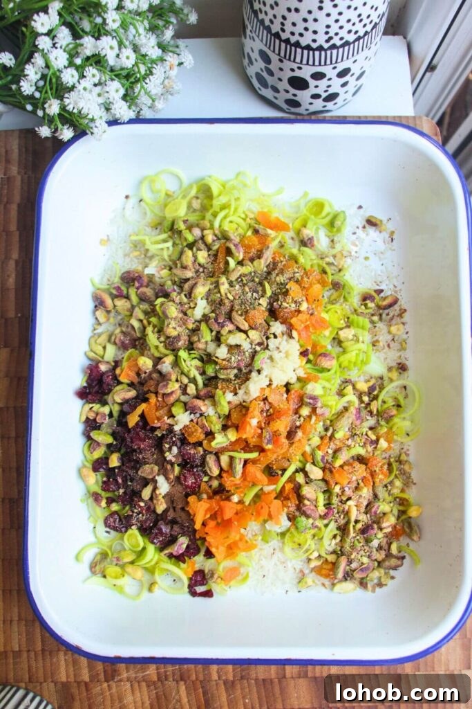 Rice, leeks and seasoning in a large white oven dish.