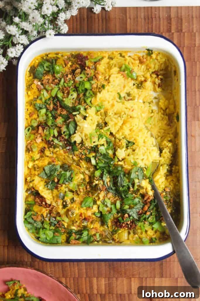 Baked loaded rice with a large silver spoon.