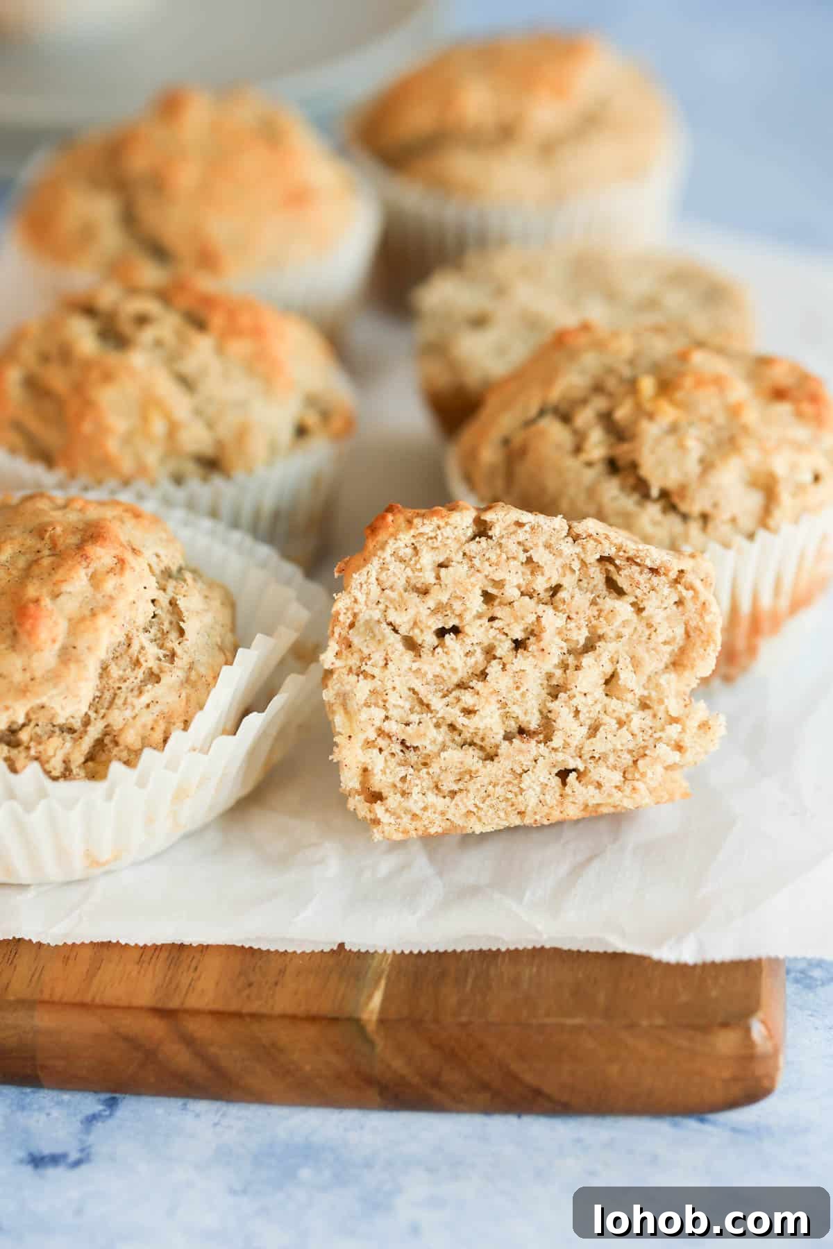 Banana bread muffins on a wooden cutting board.