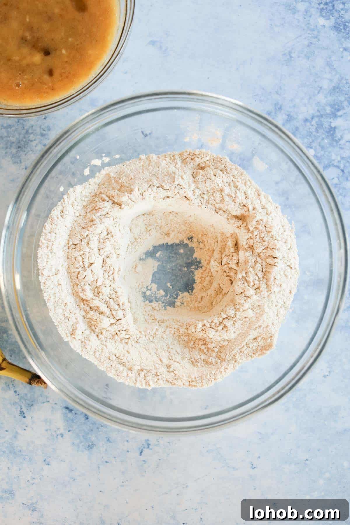 A bowl of flour hollowed out in the middle.