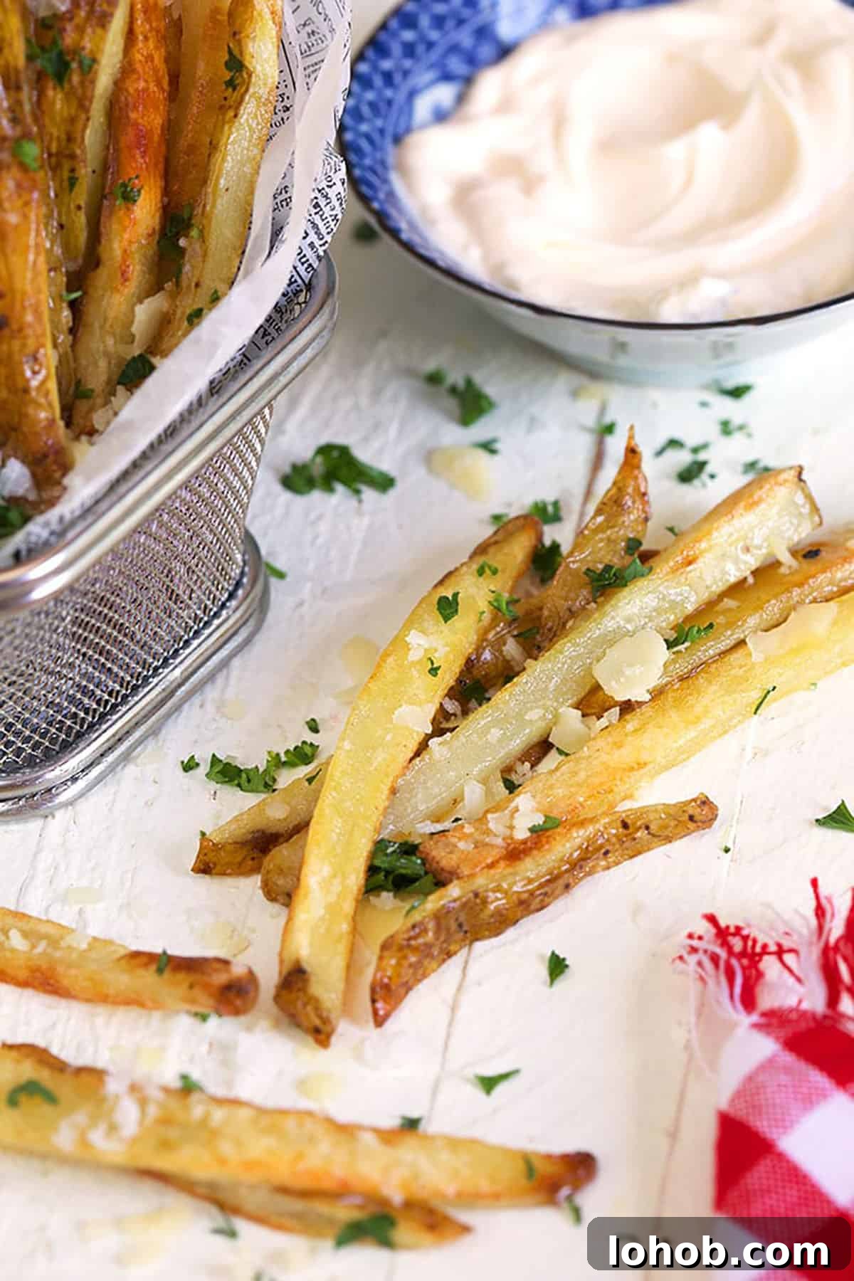 Crispy Parmesan Truffle Fries Recipe with Garlic and Herbs 3 parmesan truffle fries on a white background.