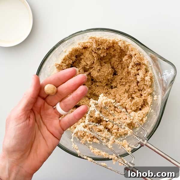 Gluten-Free Peanut Butter and Jelly Thumbprint Cookies 5 The peanut butter cookie dough in a glass mixing bowl and beers.