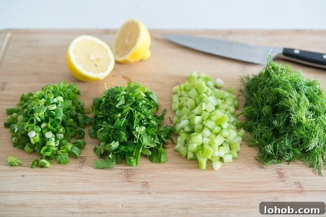 Fresh Mediterranean Salmon Salad with Lemon Herb Dressing 4 Chopped Scallions, Celery, Parsley, Herbs, and Lemon on Wooden Board