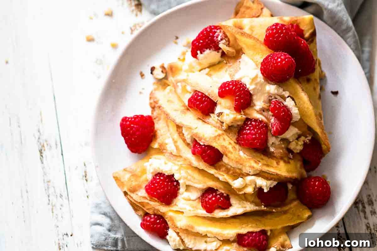 25 Morning Breakfast Ideas to Refresh Your Weekly Menu 12 Plate of folded crepes with raspberries filling.