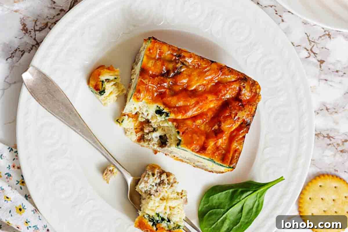 25 Morning Breakfast Ideas to Refresh Your Weekly Menu 3 Sausage egg strata slice on white plate.