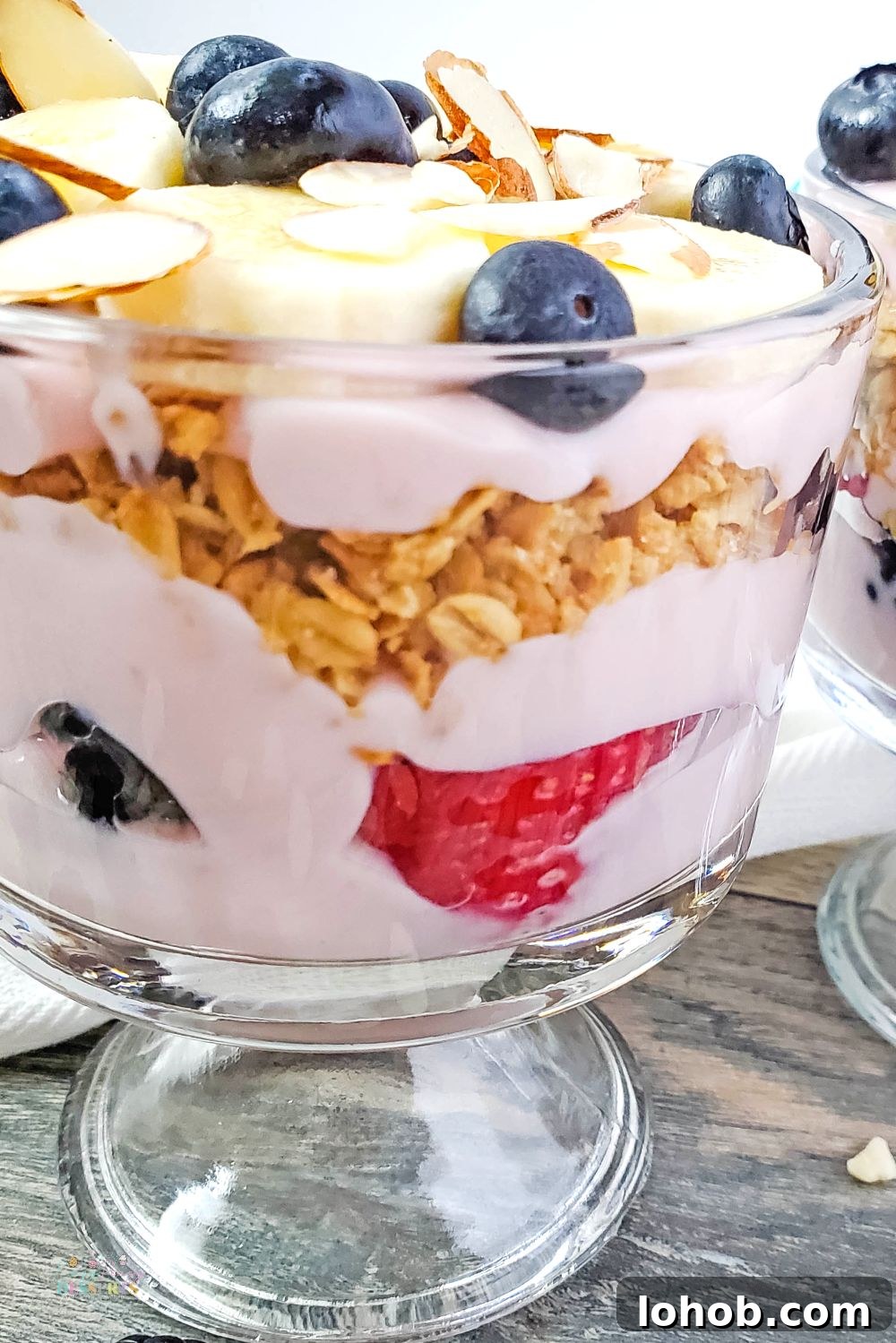 Berry Yogurt and Banana Trifle Recipe — Layered Summer Dessert 3 Close up image of mixed berry trifle with granola and banana