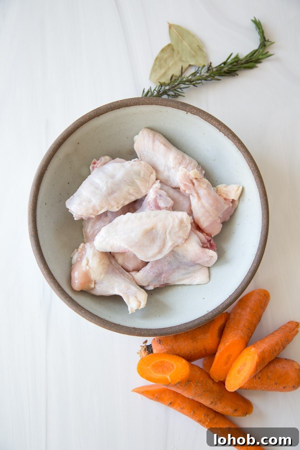 Gut-Healing Low FODMAP Chicken Stock Recipe (Gluten-Free) 3 chicken wings in a bowl next to carrots and low fodmap herbs before going in the Slow Cooker