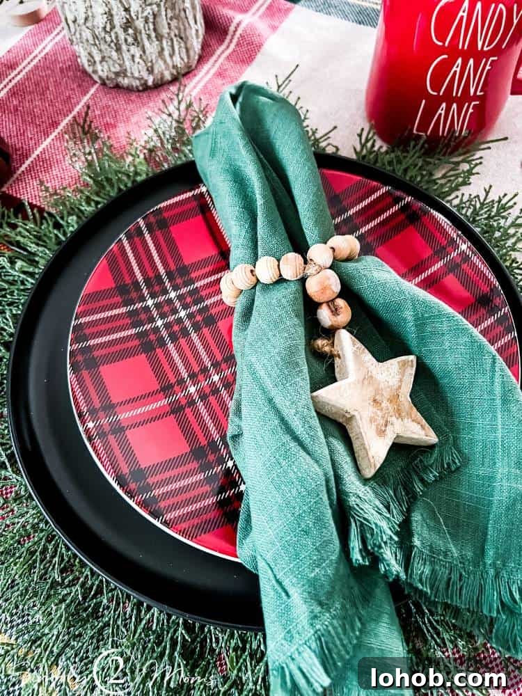 green napkin with fringe and wood bead and star ring on plaid plate