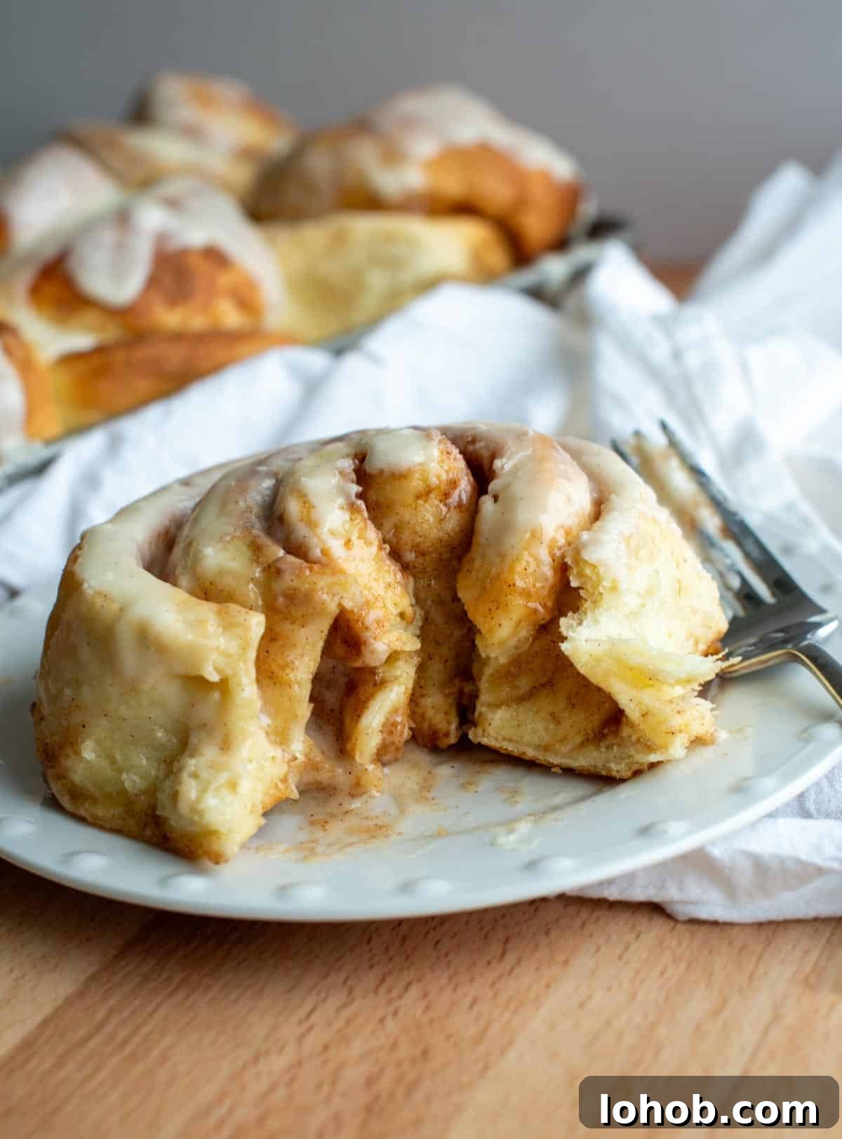 Soft Gooey Cinnamon Rolls Recipe for Perfectly Fluffy Layers 2 Cinnamon roll cut open on a plate.