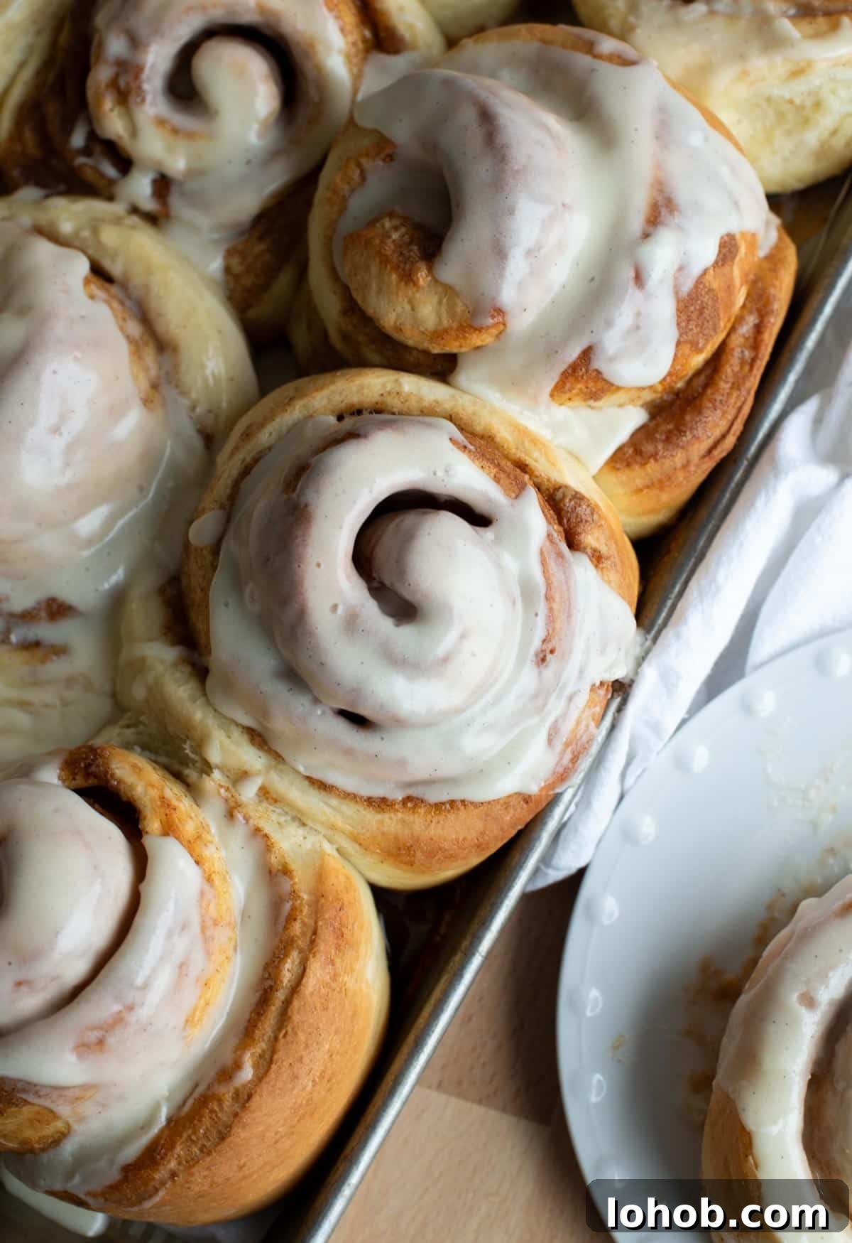 Soft Gooey Cinnamon Rolls Recipe for Perfectly Fluffy Layers 17 Cinnamon roll in a pan with icing on top.