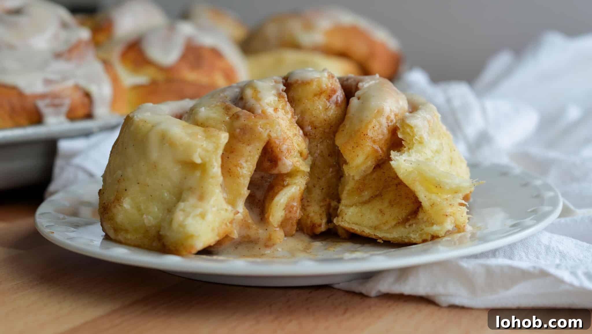 Soft Gooey Cinnamon Rolls Recipe for Perfectly Fluffy Layers 18 Cinnamon roll cut open on a plate.