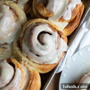 Soft Gooey Cinnamon Rolls Recipe for Perfectly Fluffy Layers 23 Cinnamon roll in a pan with icing on top.