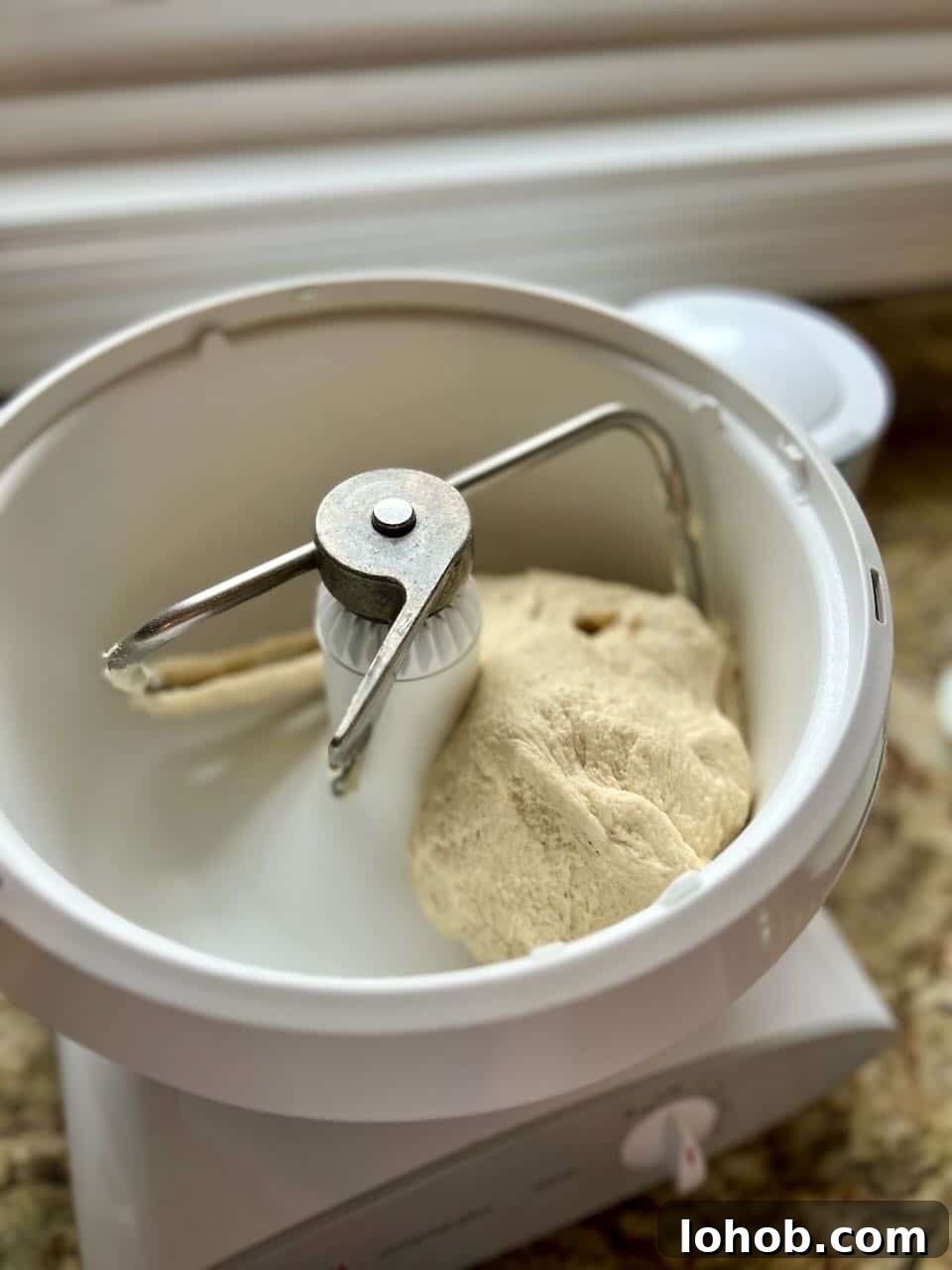 Soft Gooey Cinnamon Rolls Recipe for Perfectly Fluffy Layers 6 A stand mixer turns dough that is pulling away from the sides.