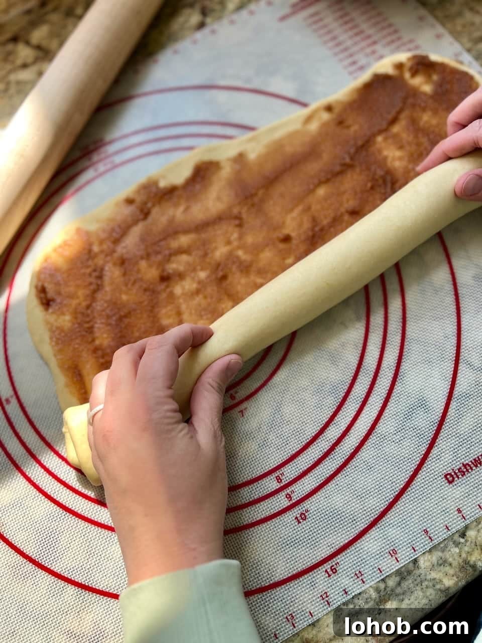 Soft Gooey Cinnamon Rolls Recipe for Perfectly Fluffy Layers 9 Hands roll the large dough rectangle that has been covered in cinnamon sugar filling.