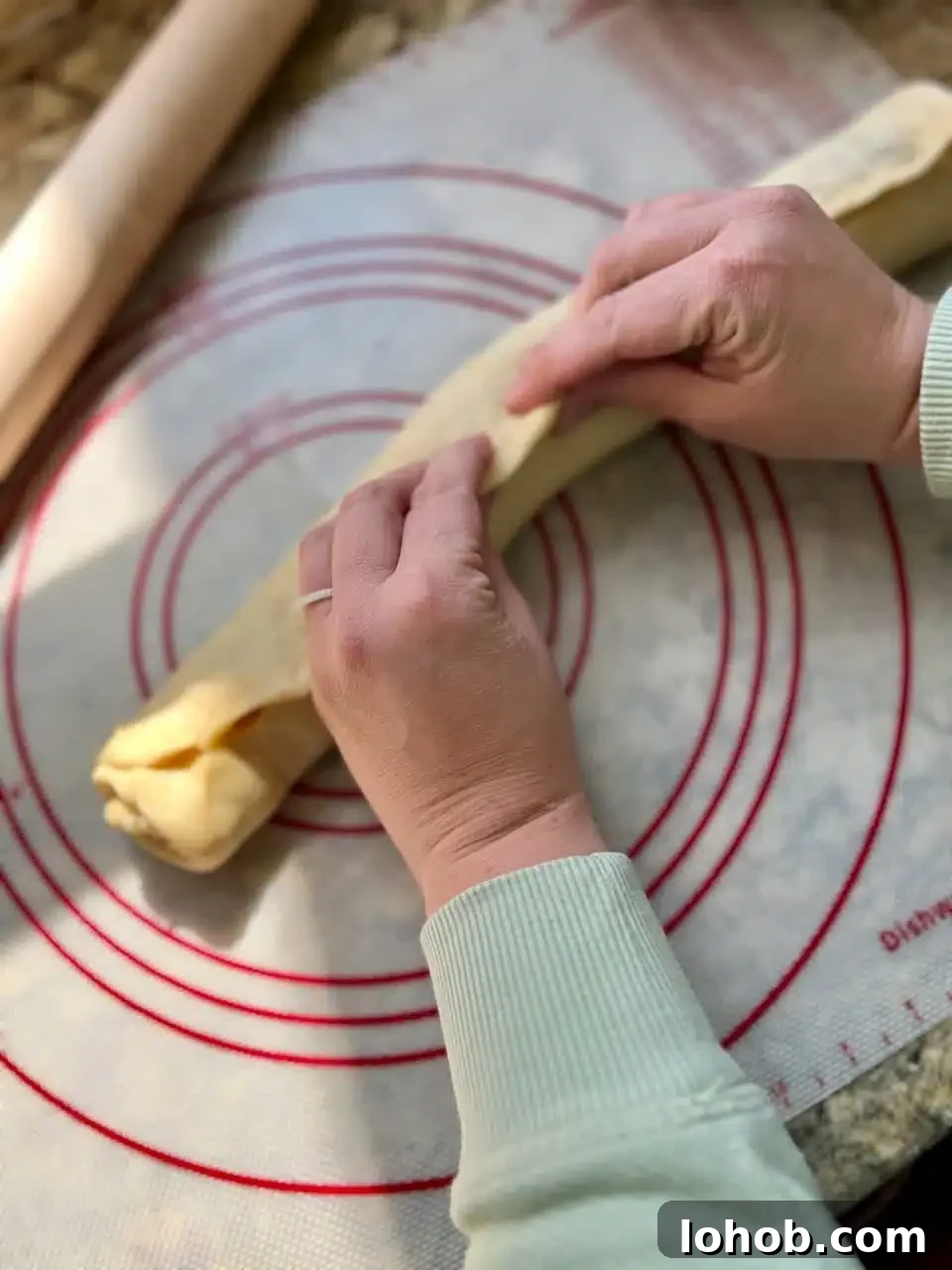 Soft Gooey Cinnamon Rolls Recipe for Perfectly Fluffy Layers 10 Hands pinch together the seam of the cinnamon roll log.