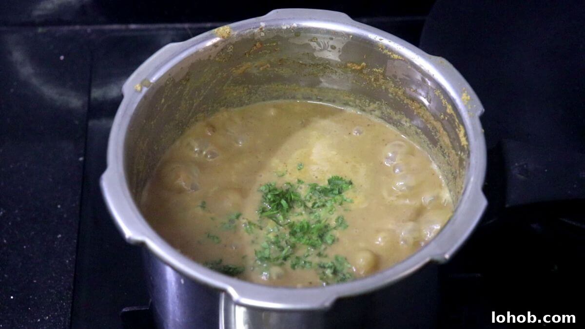 Simmering alsanyache tonak curry until thick.