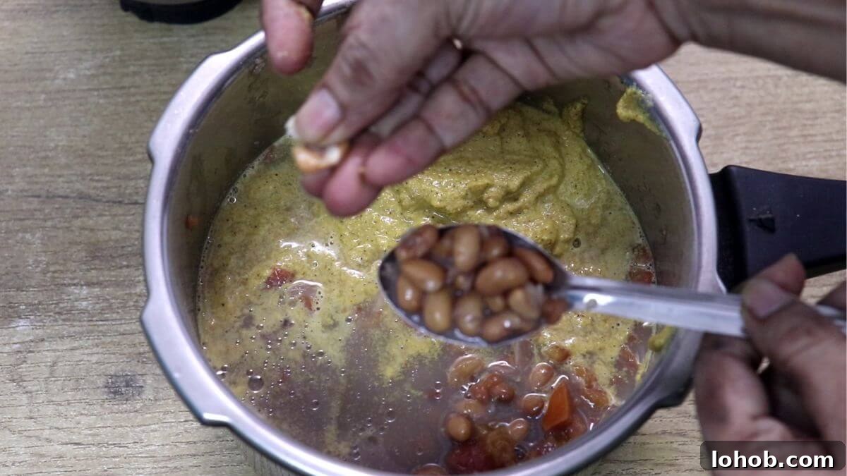showing cooked alsane by pressing it between thumb and index finger.
