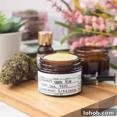 Cannabis-infused vapor rub jar with herbs and essential oils on wooden surface.